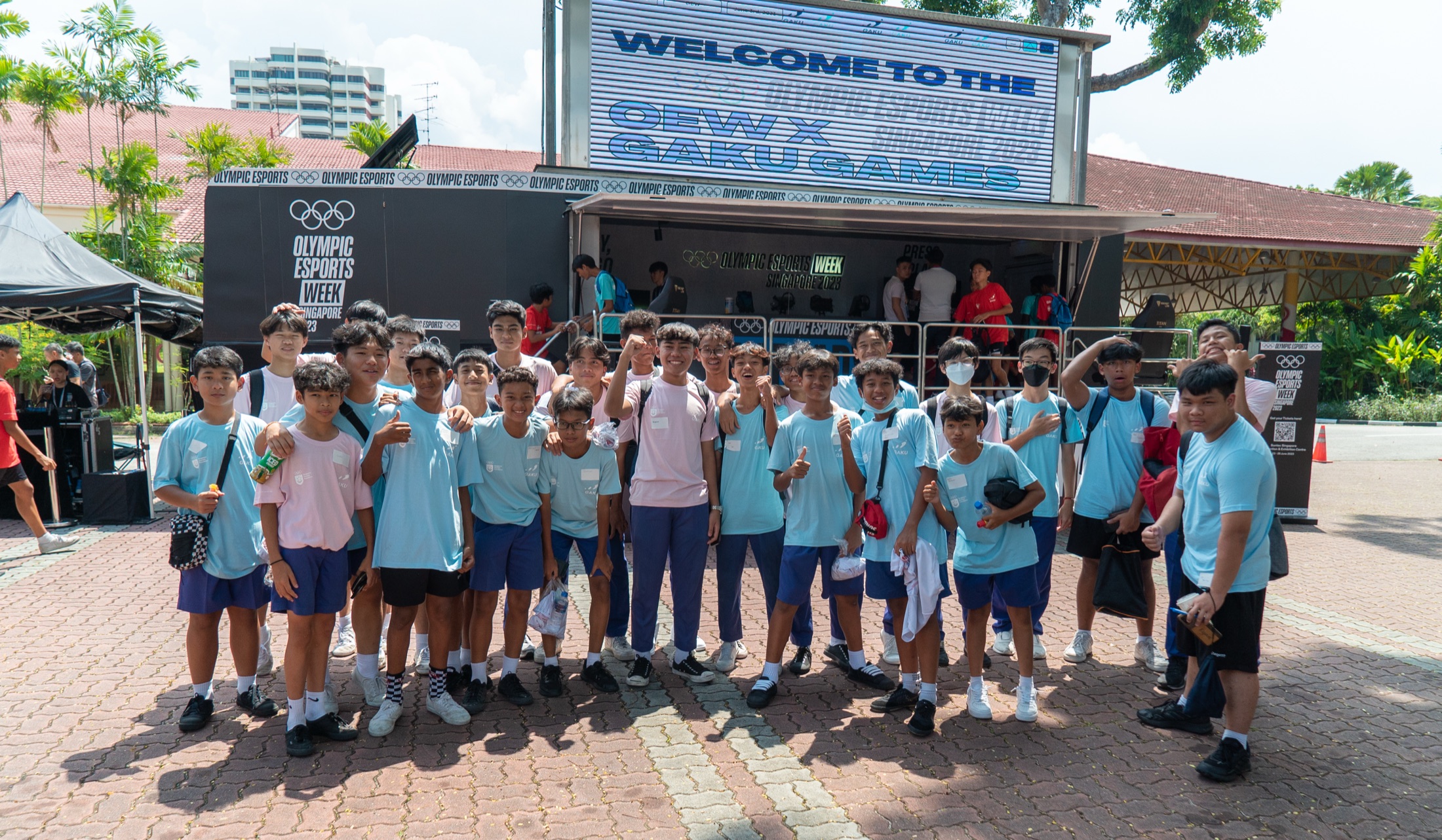 GAKU Games school cohort at Olympic Esports Week Singapore with the GAKU Games board visible